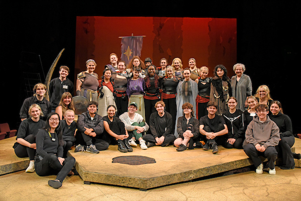 a group of students poses on stage for a company photo of Julius Caesar