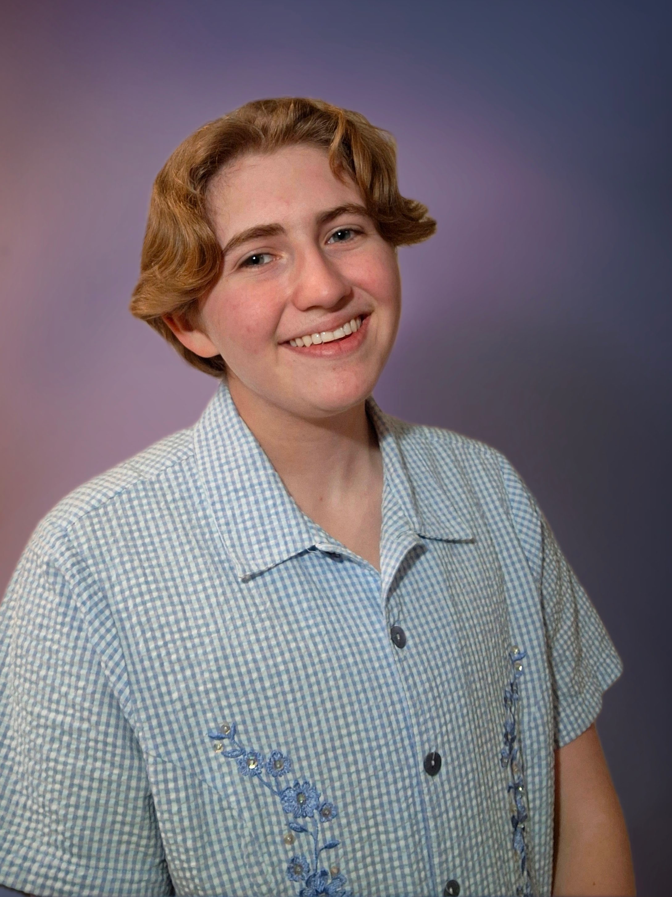 Andy smiles at the camera wearing a light blue button-up shirt