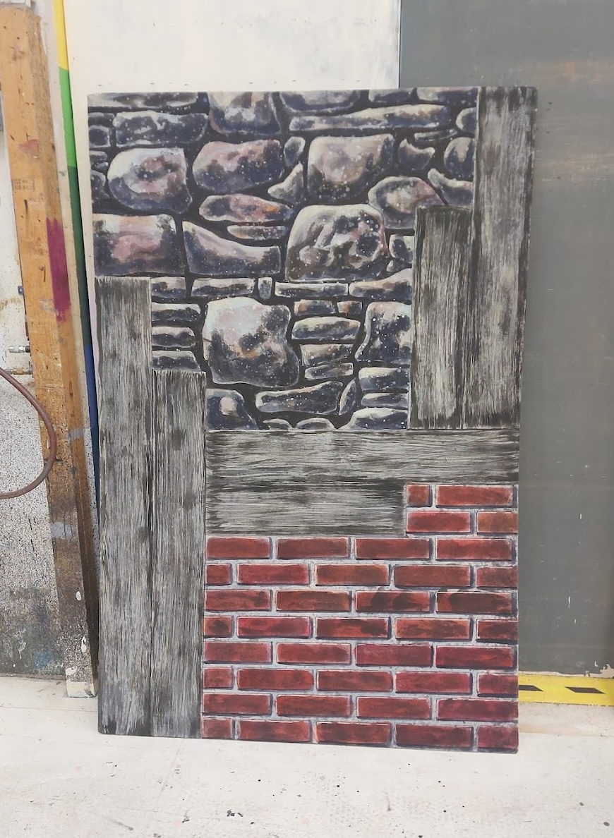 painted image of bricks, wood planks, and stones