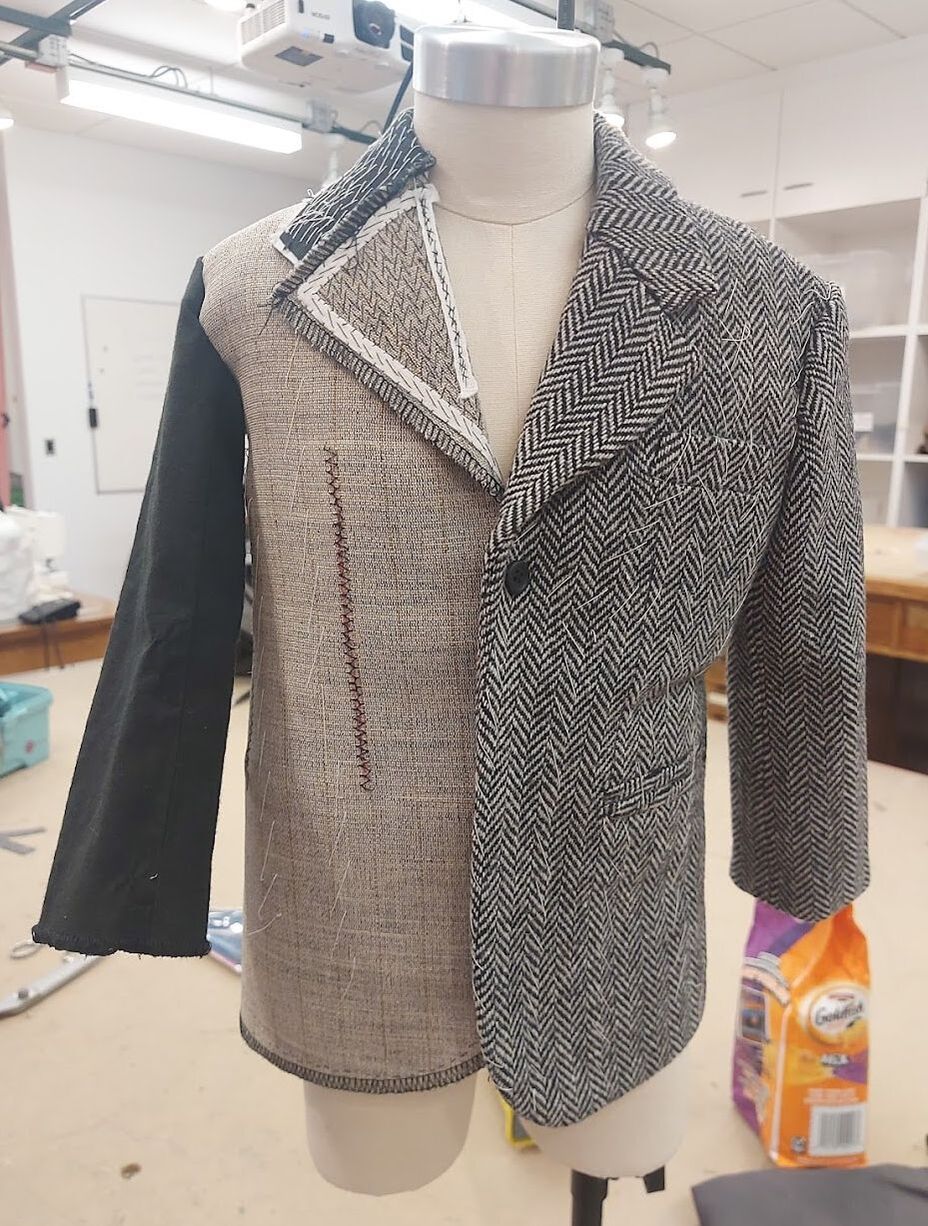 Front of a half-scale hand tailored suit jacket, half with wool and half with just the canvas